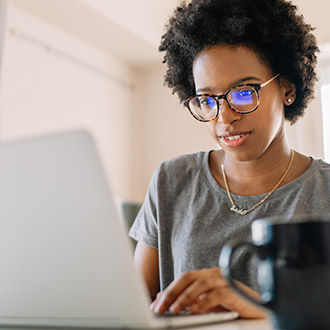 Woman using laptop with a lens reflection